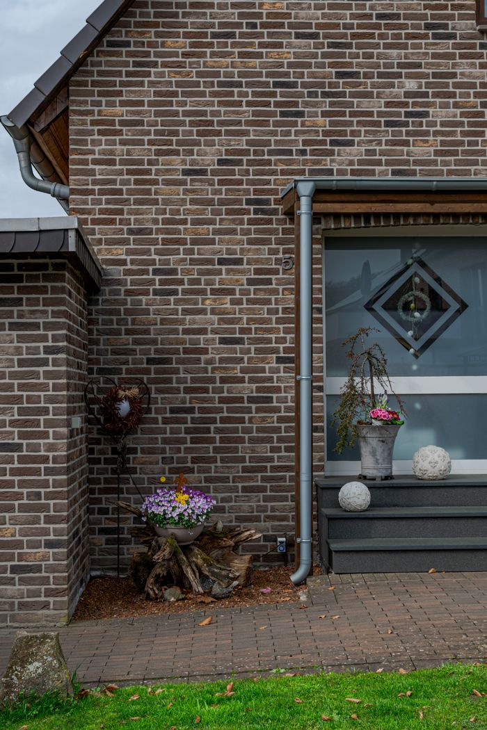 A modern brick house frontage with garden decorations in Coesfeld, Germany.